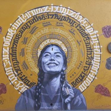 A mural of a woman and indigenous Mexican lettering